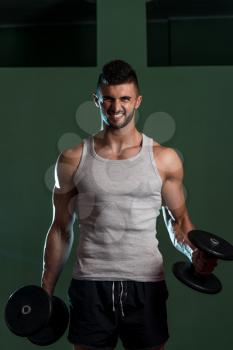 Muscular Man Exercising Biceps With Dumbbells