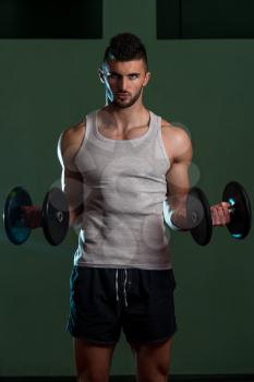 Young Man Lifting Dumbbell In Gym