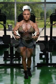Woman Bodybuilder Is Working On Her Chest With Cable Crossover In Gym