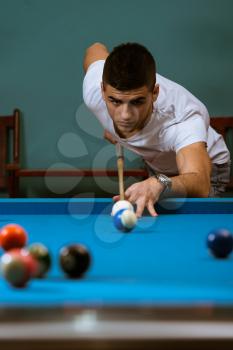 Young Men Lining To Hit Ball On Pool Table