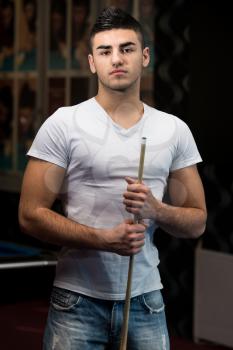 Portrait Of A Young Male Model Playing Billiards
