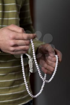 Close-Up Of Young Muslim Man With Rosary Praying In Mosque