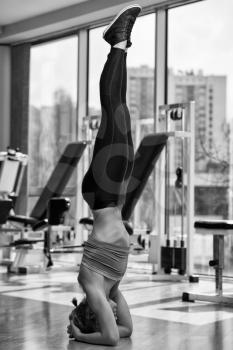 Young Attractive Girl Doing The Headstand In Healthy Club