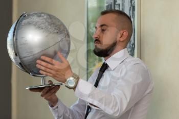 Young Businessman Holding Globe