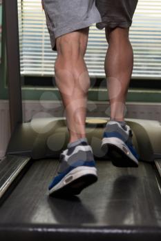 Close-Up Of Male Legs Running On Treadmill - Blurred Motion