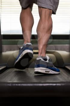 Close-Up Of Male Legs Running On Treadmill - Blurred Motion