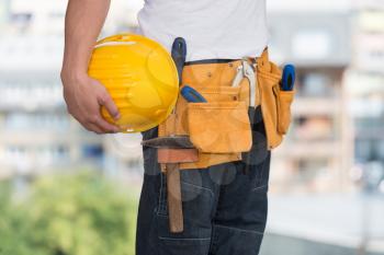 Close-Up Of Hard Hat Holding By Construction Worker