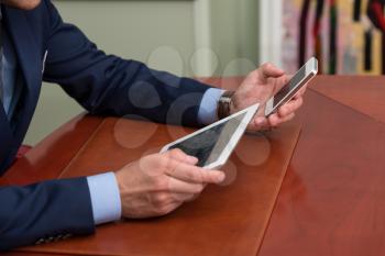 Young Businessmen Using Touchpad At Meeting