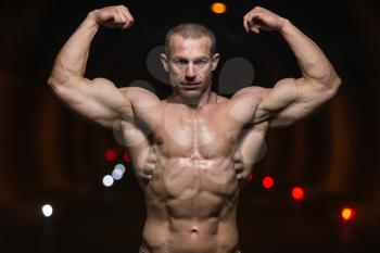 Bodybuilder Performing Front Double Biceps Poses In Tunnel
