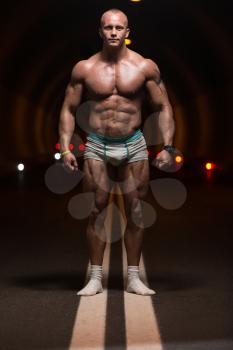 Bodybuilder Performing Front Relaxed Poses In Tunnel