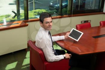 Portrait Of A Young Business Man Using A Touchpad In The Office