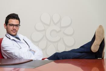 Young Doctor Relaxes Sitting In The Office