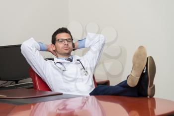 Young Doctor Relaxes Sitting In The Office
