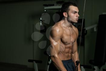 Young Man Exercise In The Gym - He Is Performing Two Arm Triceps Push Downs
