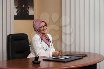 Muslim Doctor Relaxes Sitting In The Office