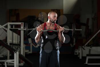 Mature Man Working Out Biceps In A Health Club