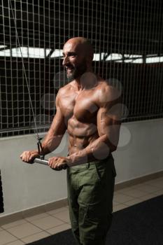 Mature Bodybuilder Exercise In The Gym - He Is Performing Two Arm Triceps Push Down