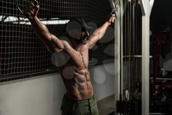 Mature Bodybuilder Is Working On His Chest With Cable Crossover In A Dark Gym