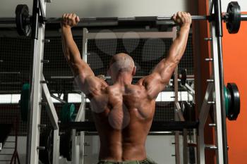Mature Man Doing Shoulder Exercises In The Gym
