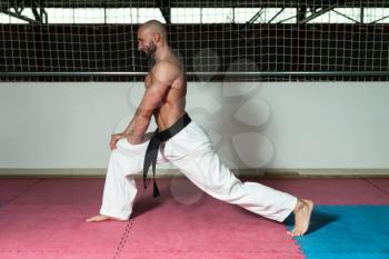 Male Martial Arts Instructor Preparing For Class - Warming Up and Stretching