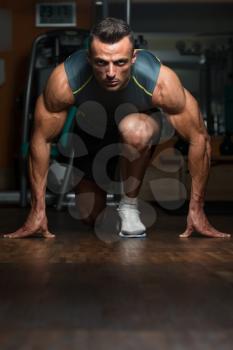 Strong Muscular Men Kneeling On The Floor - Almost Like Sprinter Starting Position