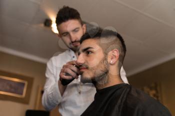 Handsome Young Hairdresser Giving A New Haircut To Male Customer At Parlor