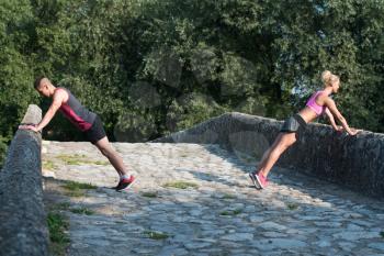 Young Couple Doing Pushups Before Running Outdoors - Fitness Healthy Lifestyle Concept