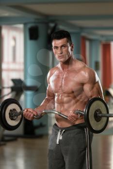 Muscular Young Man Doing Heavy Weight Exercise For Triceps In Modern Fitness Center
