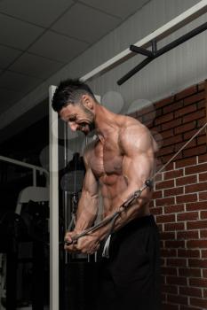 Bodybuilder Is Working On His Chest With Cable Crossover In A Dark Gym