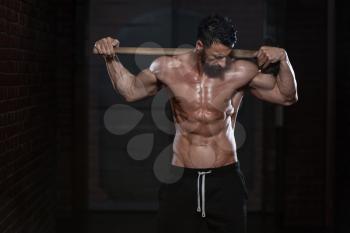 Portrait Of A Physically Fit Man Showing His Well Trained Body And Holding A Hammer