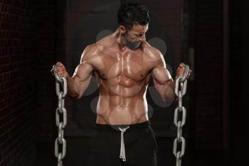 Healthy Bodybuilder Exercising Biceps With Chains