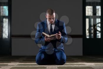 Muslim Businessman Reading Holy Islamic Book Koran In The Mosque