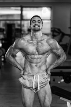 Awesome Bodybuilder Showing His Muscles And Posing In Gym