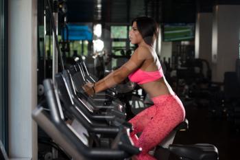 Fitness Girl Exercising On Bike Working Out In A Gym