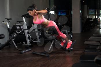 Young Latina Woman Working Out Back On Machine In Fitness Center