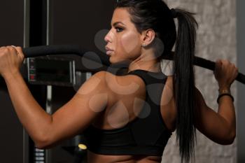 Sexy Latino Woman Working Out Back On Machine In Fitness Center