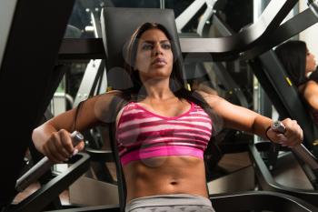Young Latina Woman In Gym Exercising On The Bench Press