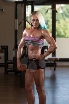 Portrait Of A Middle Aged Woman Posing Bodybuilding Poses In Modern Fitness Center