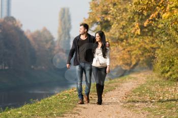 Couple Walking In Forest Through The Woods Outside During Autumn