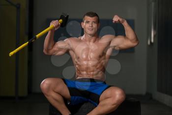 Athletic Man Resting - Workout At Gym With Hammer And Tractor Tire