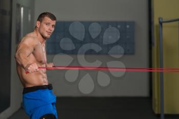 Muscular Man Training Stretching With Fitness Rubber Bands