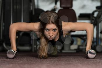 Young Adult Athlete Doing Push Ups With Dumbbells As Part Of Bodybuilding Training