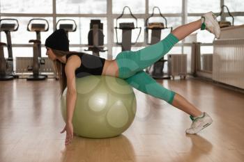 Woman Exercising Pilates Ball Workout Posture In Fitness Club