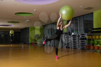 Young Woman Working Out With Ball In Fitness Center