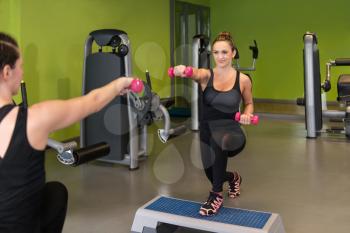Strong Young Women Doing Exercise With Dumbbells In The Gym
