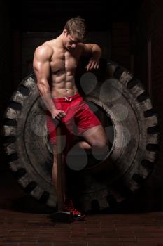 Athletic Man Resting - Workout At Gym With Hammer And Tractor Tire