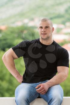 Happy Muscular Man In Black T-Shirt Standing And Showing His Muscle