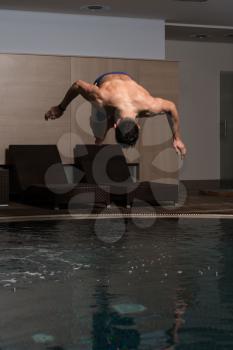 Young Man Jumping Into The Water Swimming Pool