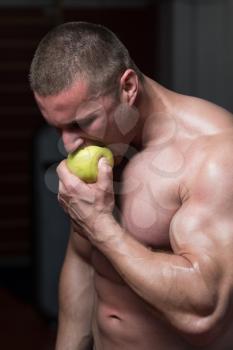 Male Sportsman Bites Green Apple After Training