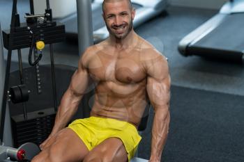 Attractive Young Man Doing Leg Exercises With Machine In Gym